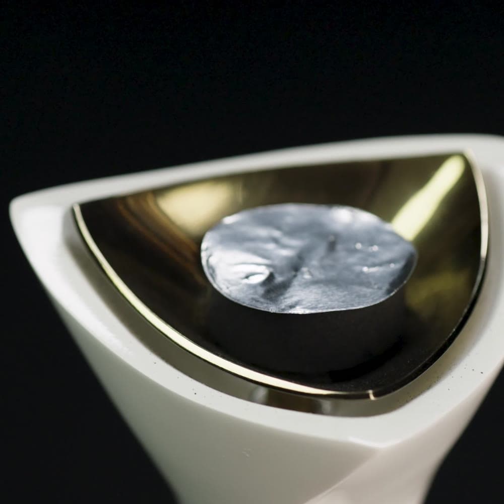 A disc of thick aluminium foil on the charcoal in the burner
