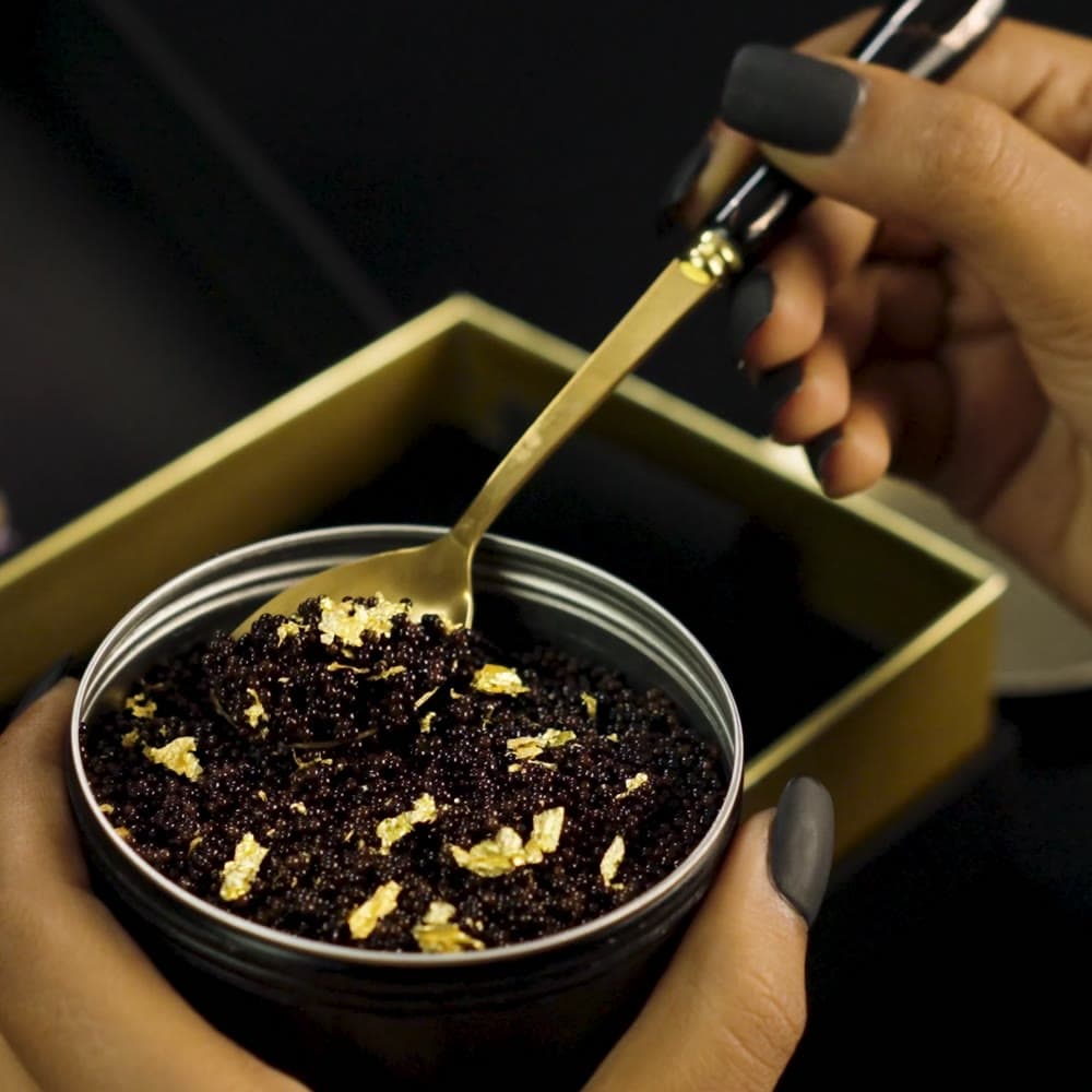 The gold spoon scooping pearls from the open tin