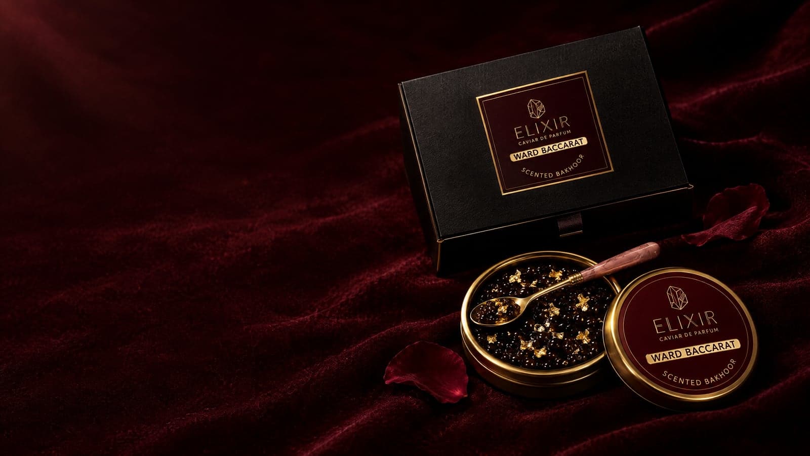 Ward Baccarat: the open tin of pearls with gold leaf, a rose-handled gold spoon, the burgundy tin and its box, on burgundy velvet with rose petals